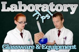 Two laboratory technicians hold up a reactor vessel to introduce our laboratory glassware and equipment article.